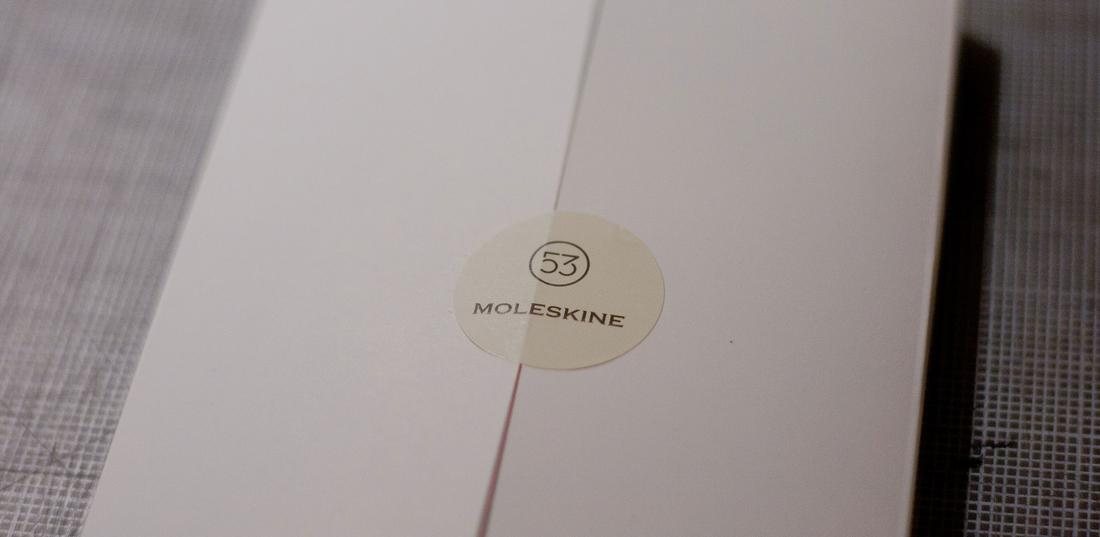 Paper Moleskine book wrap, sealed with a 53 sticker
