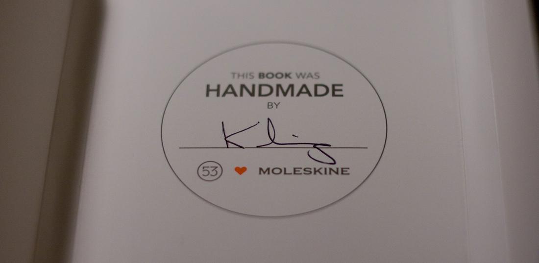 Paper Moleskine book seal with handwritten name by its maker